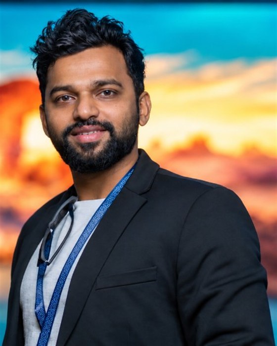Muhammed Shaheer in a black blazer against a sunset backdrop